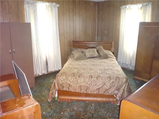 a bed sitting in a bedroom next to a window