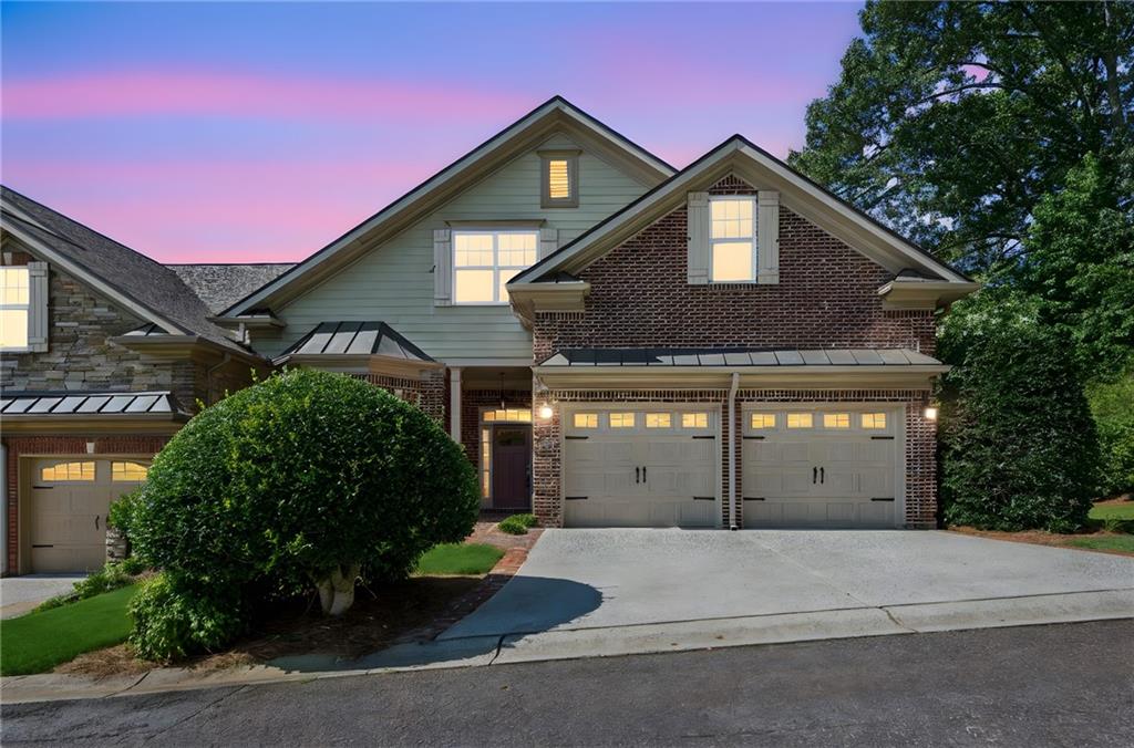 a front view of a house with a garden and garage