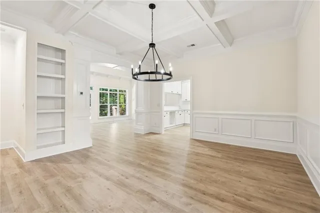 a view of empty room with wooden floor and windows