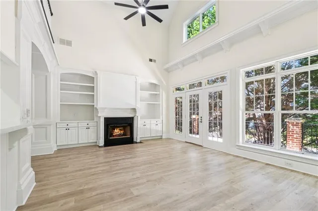 wooden floor fireplace and windows in an empty room