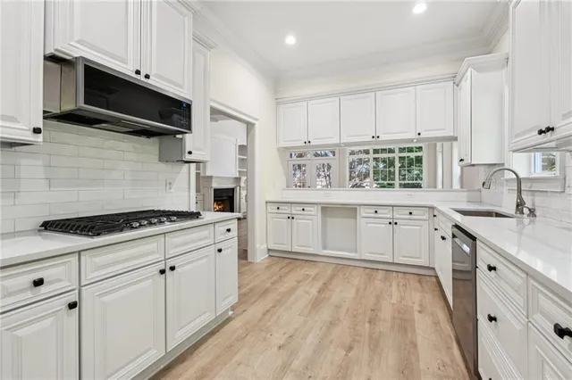 a large kitchen with stainless steel appliances granite countertop a stove a sink dishwasher and a refrigerator