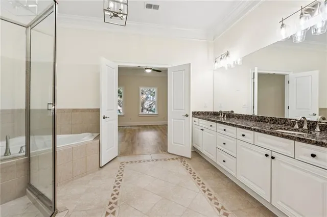 a spacious bathroom with a granite countertop sink a mirror and a bathtub