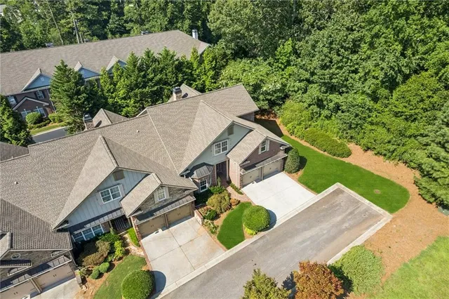an aerial view of a house with a yard and large trees