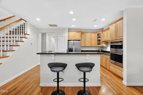 a kitchen with stainless steel appliances granite countertop a stove a sink and a refrigerator