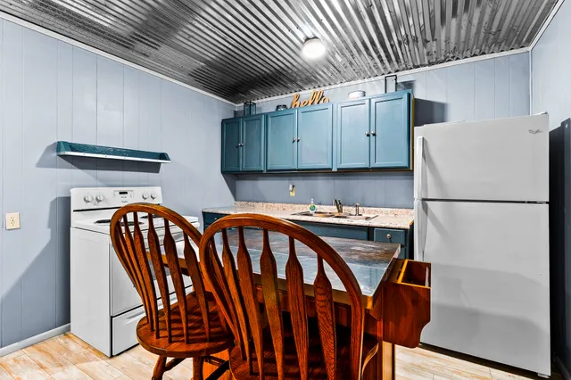 a kitchen with a sink a refrigerator and wooden floor