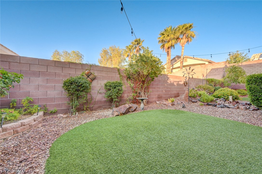 1604 Cattle Ranch Place Henderson, NV 89002 - Photo 65 of 99 A private yard with desert landscaping and low-maintenance artificial turf.