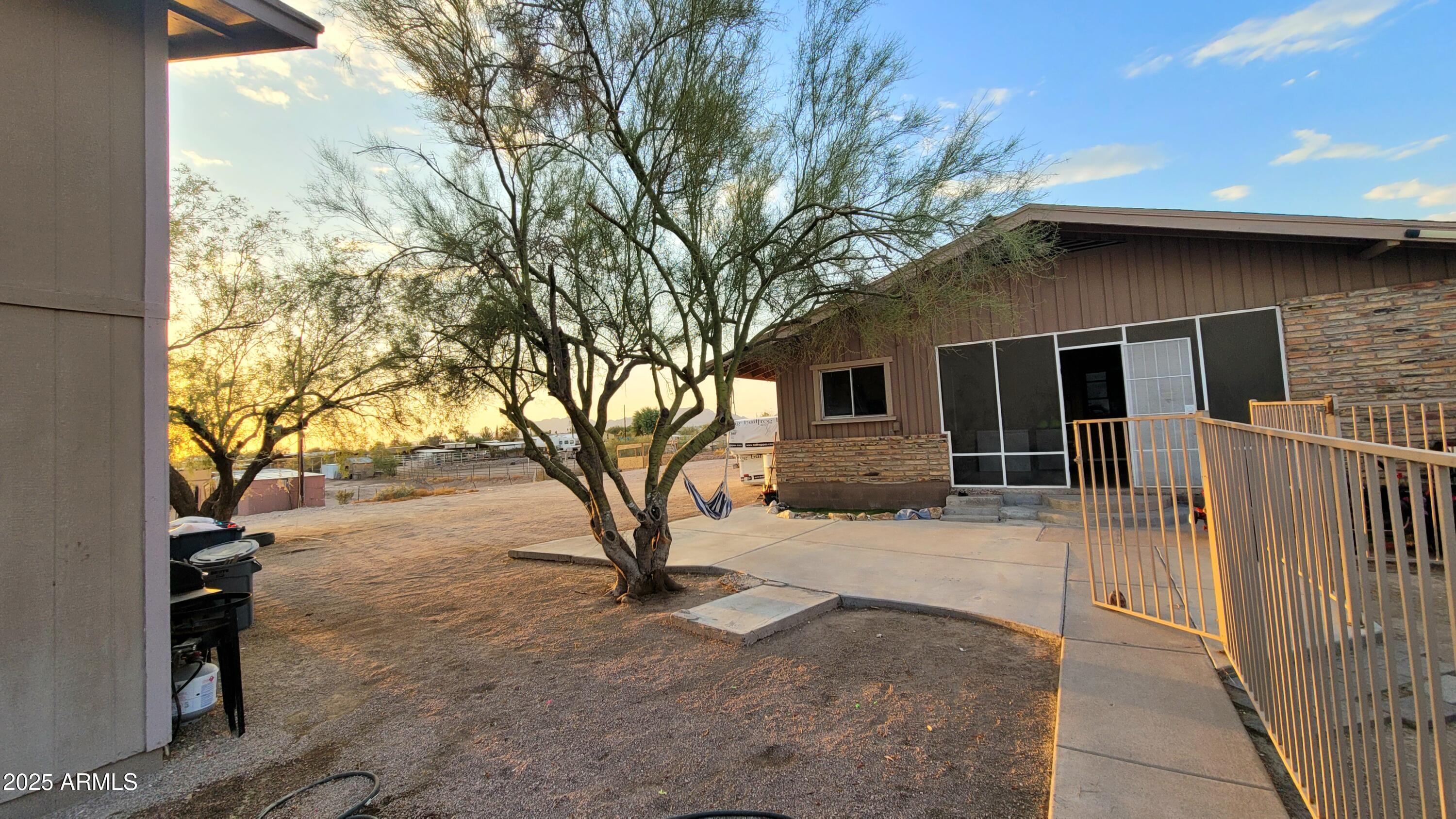 522 South Cortez Road Apache Junction, AZ 85119 - Photo 15 of 48 a backyard of a house with wooden fence and large trees