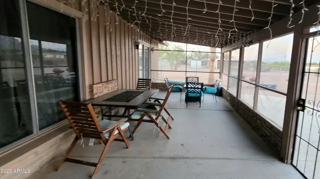 a view of a patio with table and chairs and floor to ceiling window
