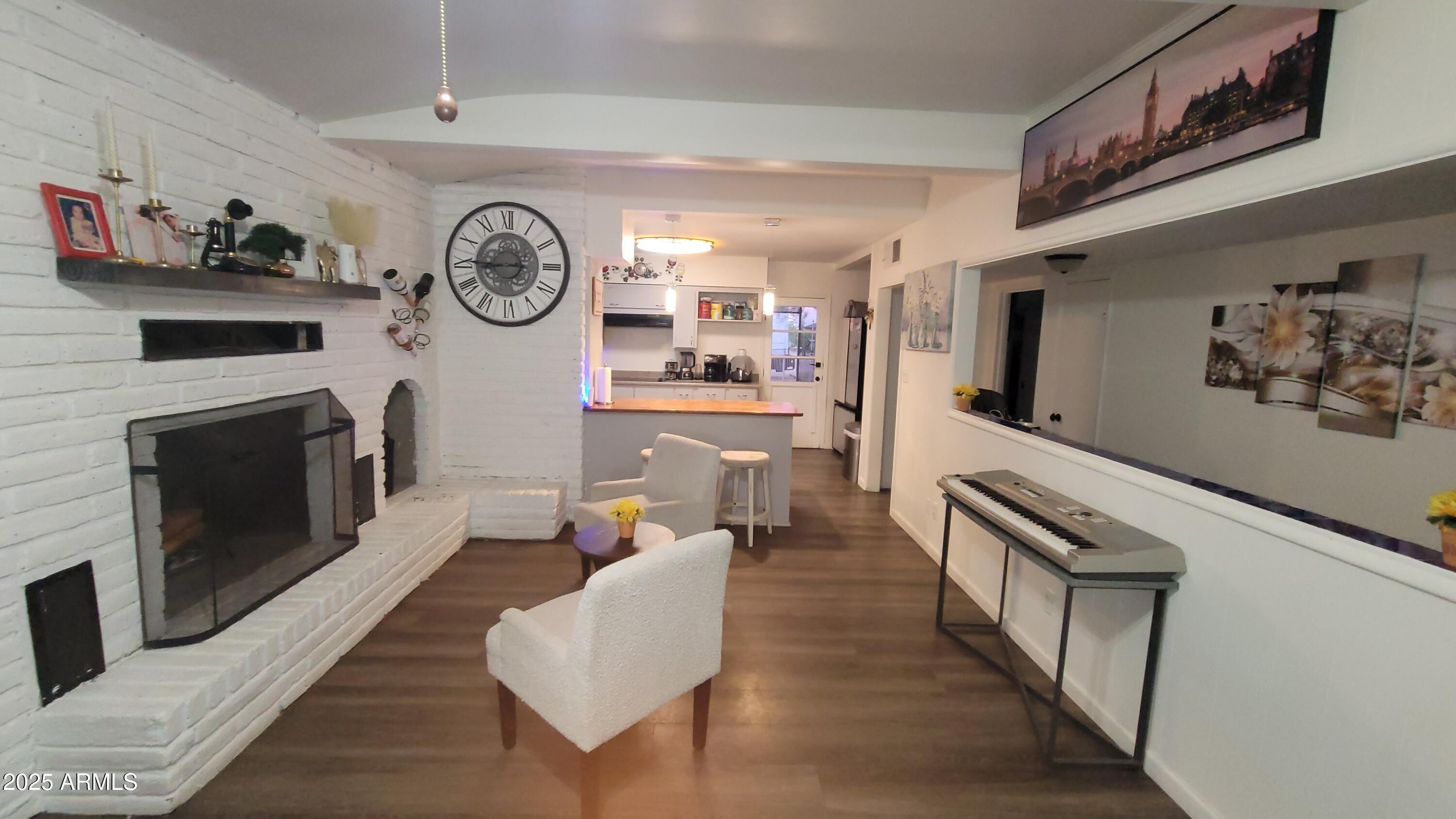 522 South Cortez Road Apache Junction, AZ 85119 - Photo 34 of 48 a living room with furniture a clock and a fireplace
