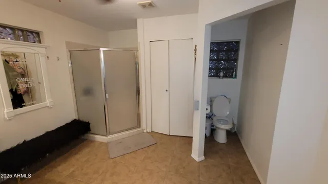 a bathroom with a toilet and a shower