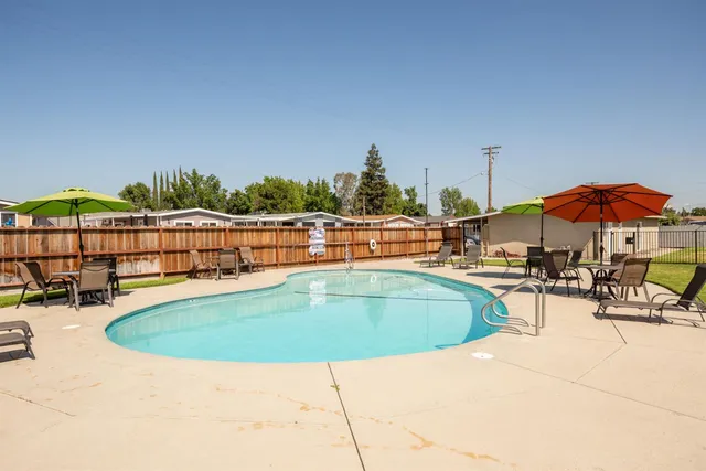 a view of a swimming pool with an outdoor seating and a yard