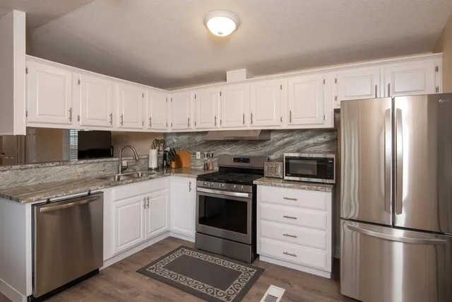 a kitchen with cabinets stainless steel appliances and a counter space