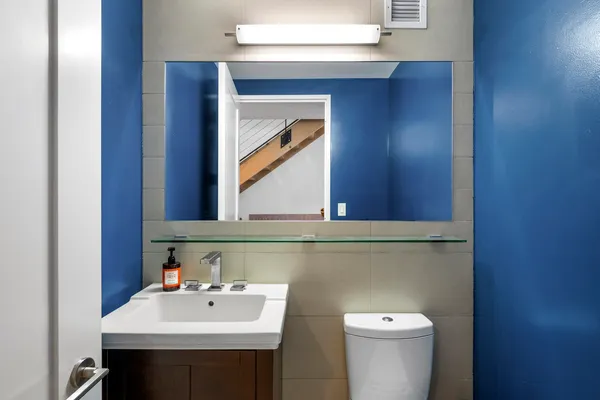 a bathroom with a sink mirror and toilet