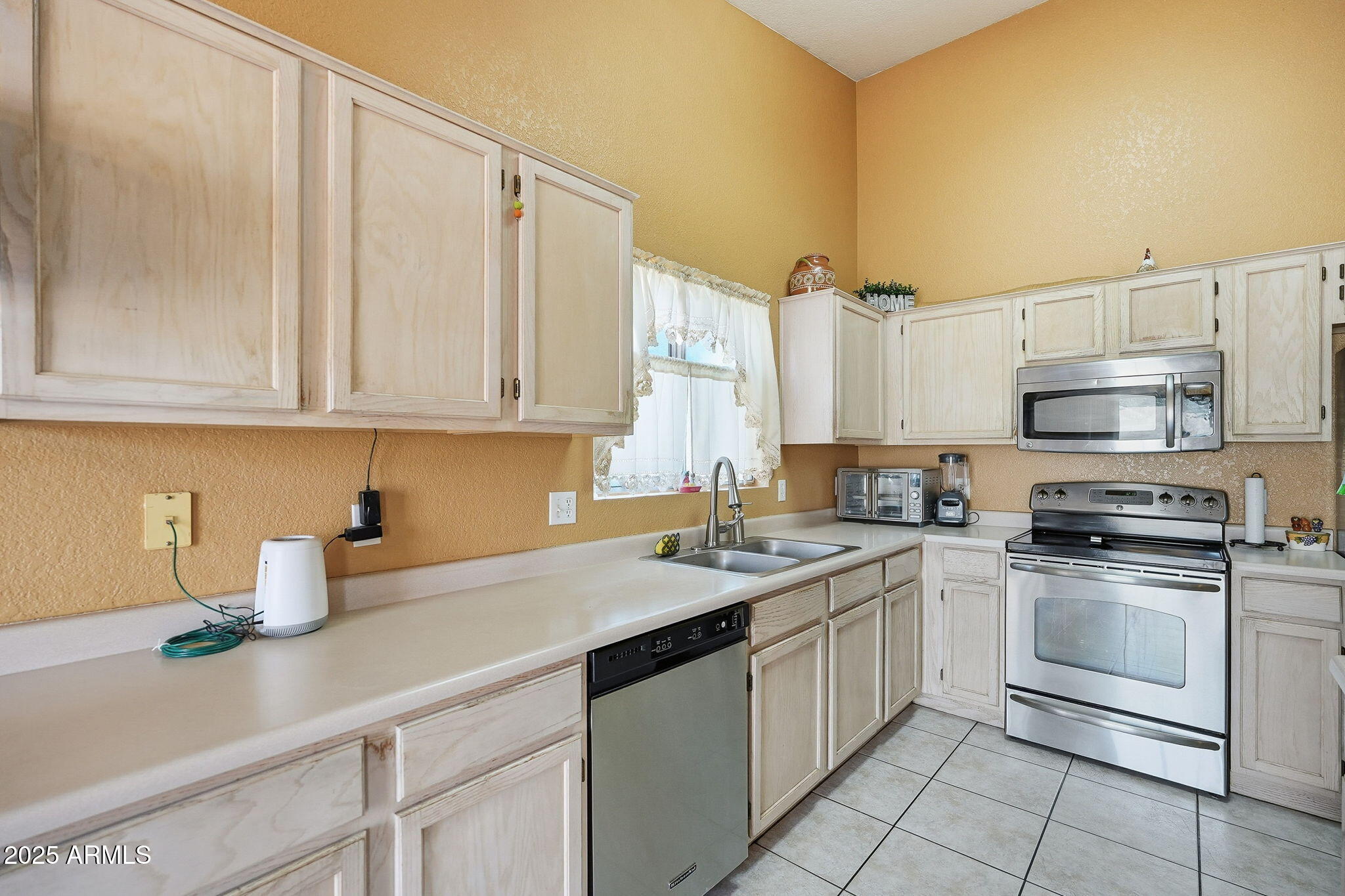 8730 West Ocotillo Road Glendale, AZ 85305 - Photo 16 of 58 a kitchen with stainless steel appliances granite countertop a sink a stove a refrigerator and cabinets