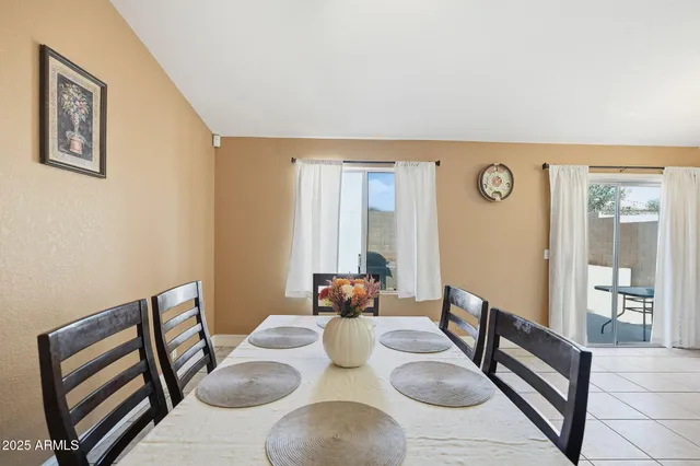 a bedroom with a bed and a large mirror on dresser next to a window