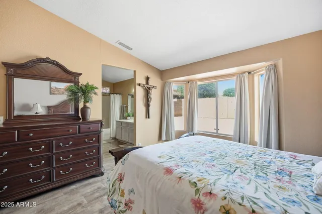 a bedroom with a bed and a painting on the wall