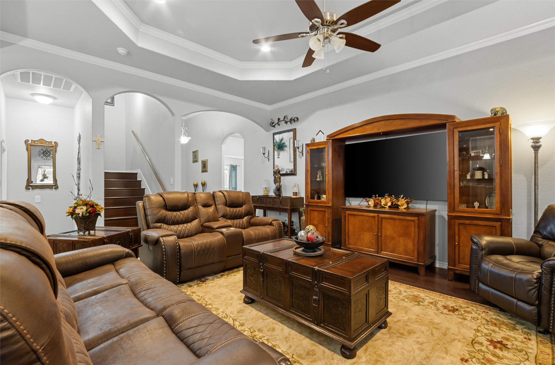 16017 Toby Court Temple, TX 76502 - Photo 4 of 33 Living area featuring a tray ceiling, stairs, ornamental molding, wood finished floors, and ceiling fan