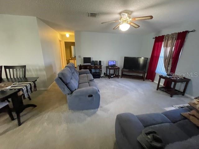 51 Foster Lane Palm Coast, FL 32137 - Photo 9 of 12 a living room with furniture a ceiling fan and a rug