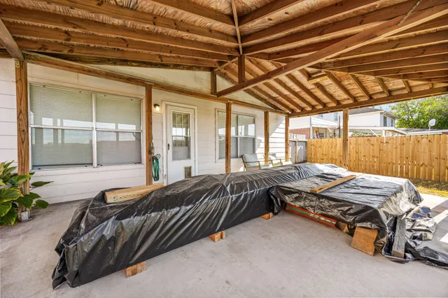 a view of backyard with lawn chairs and iron fence