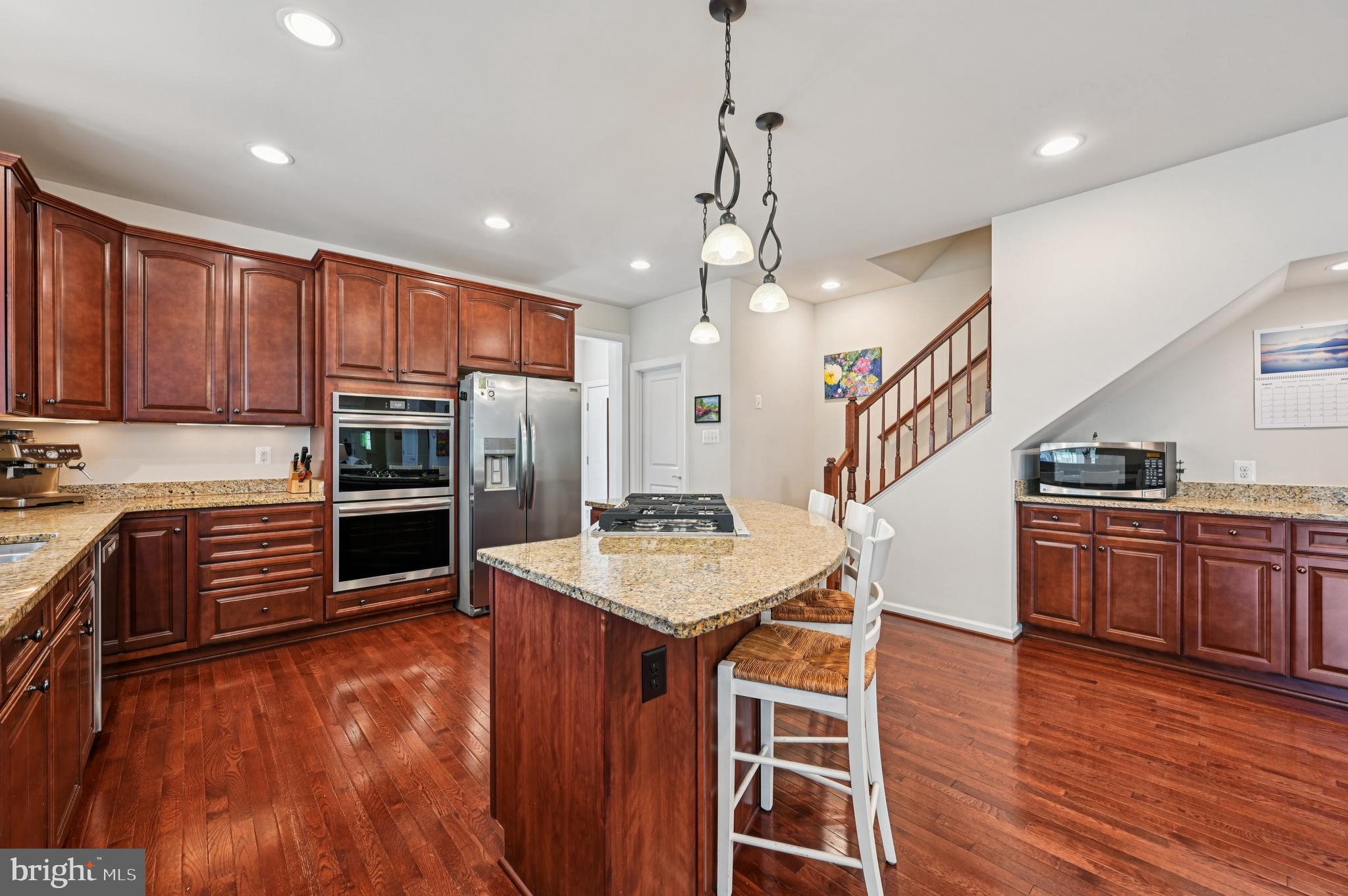 4884 Castlebridge Road Ellicott City, MD 21042 - Photo 30 of 130 a kitchen with stainless steel appliances granite countertop a refrigerator a stove top oven a sink dishwasher and a wooden cabinets with wooden floor