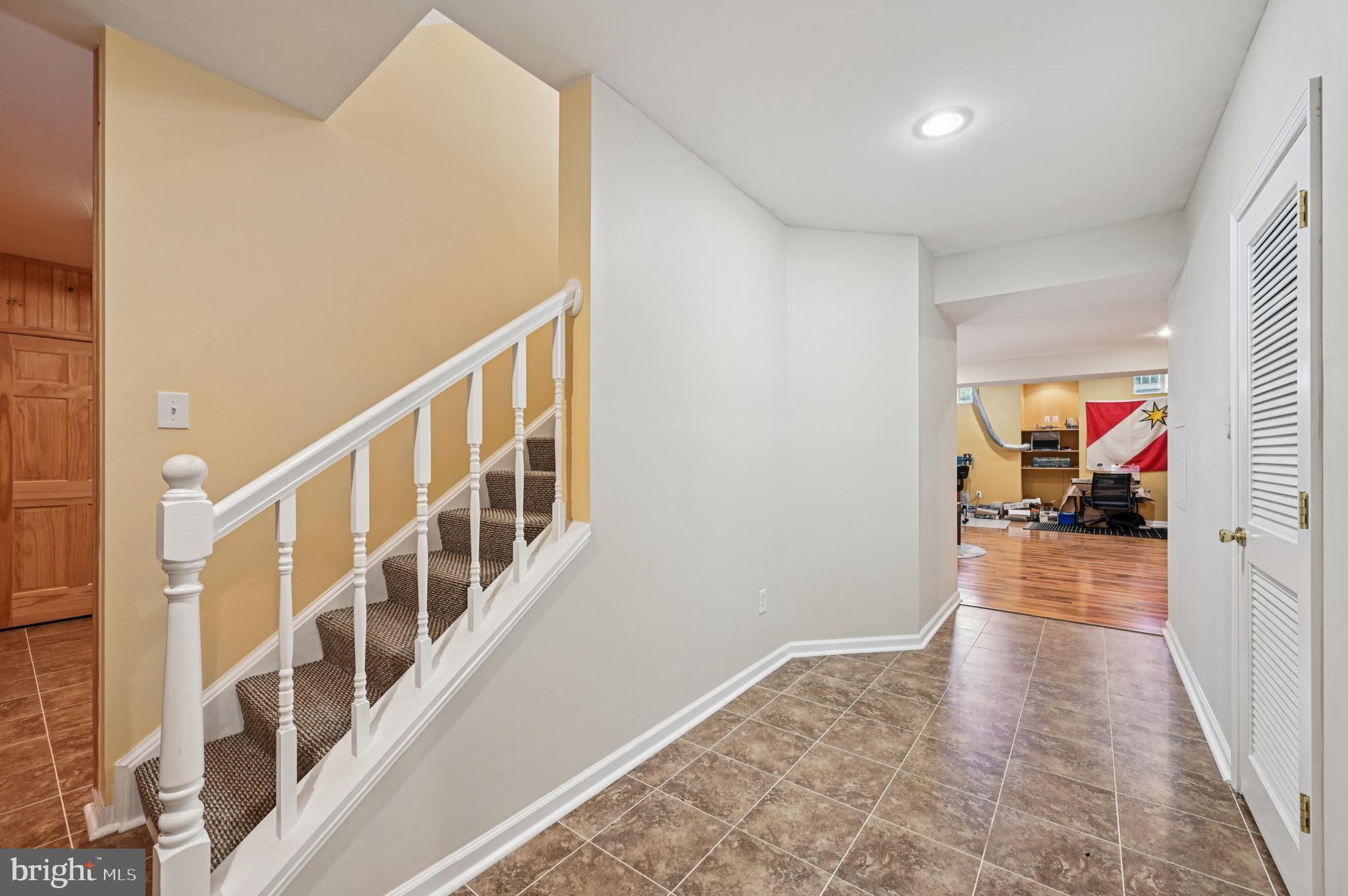 4884 Castlebridge Road Ellicott City, MD 21042 - Photo 56 of 130 a view of a hallway to a livingroom with wooden floor and stairs