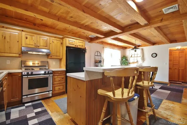 a kitchen with a stove a refrigerator and wooden floor