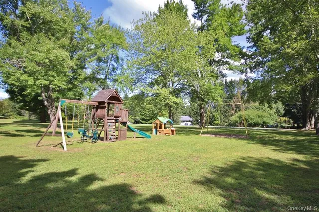 a view of a swimming pool with lawn chairs and a fire pit