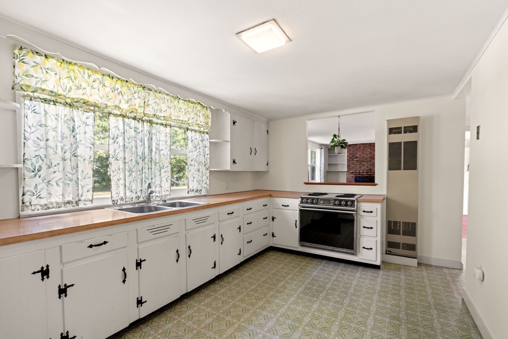 52 Middle Road Merrimac, MA 01860 - Photo 4 of 24 a large white kitchen with stainless steel appliances granite countertop a large window a sink and a stove