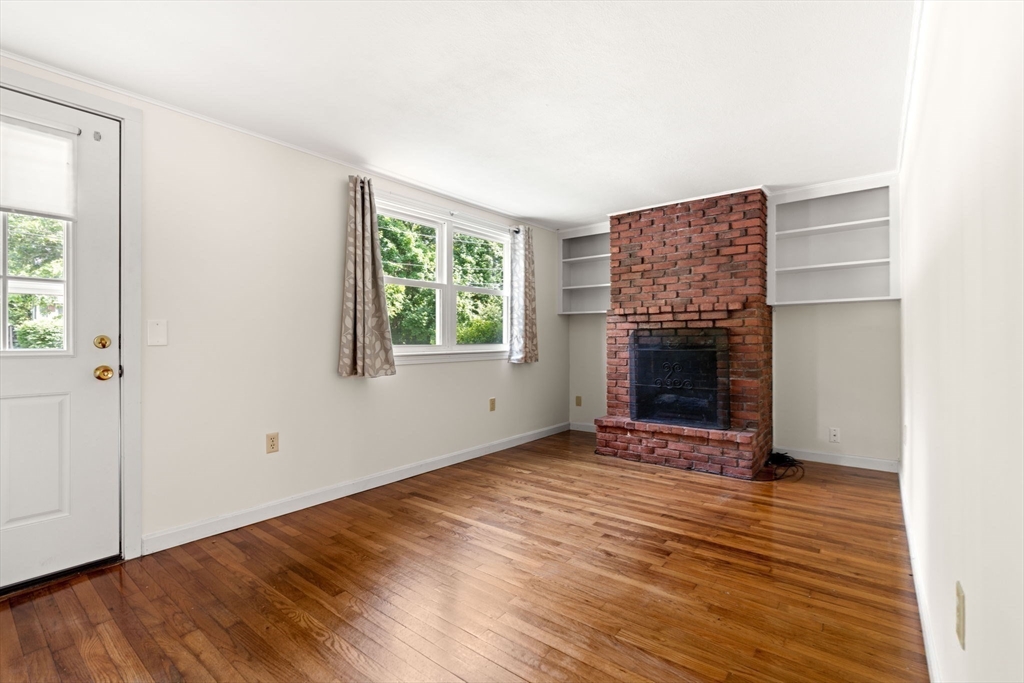 52 Middle Road Merrimac, MA 01860 - Photo 6 of 24 an empty room with wooden floor fireplace and windows
