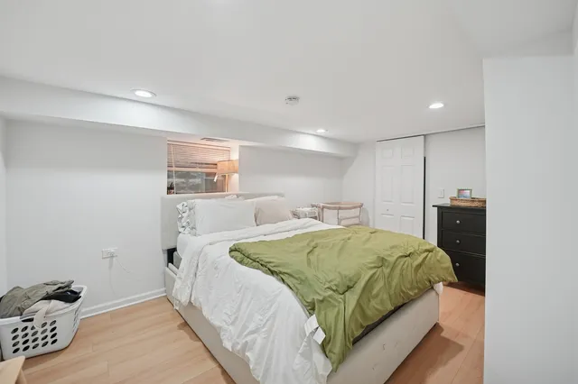 a spacious bedroom with a bed and a lamp