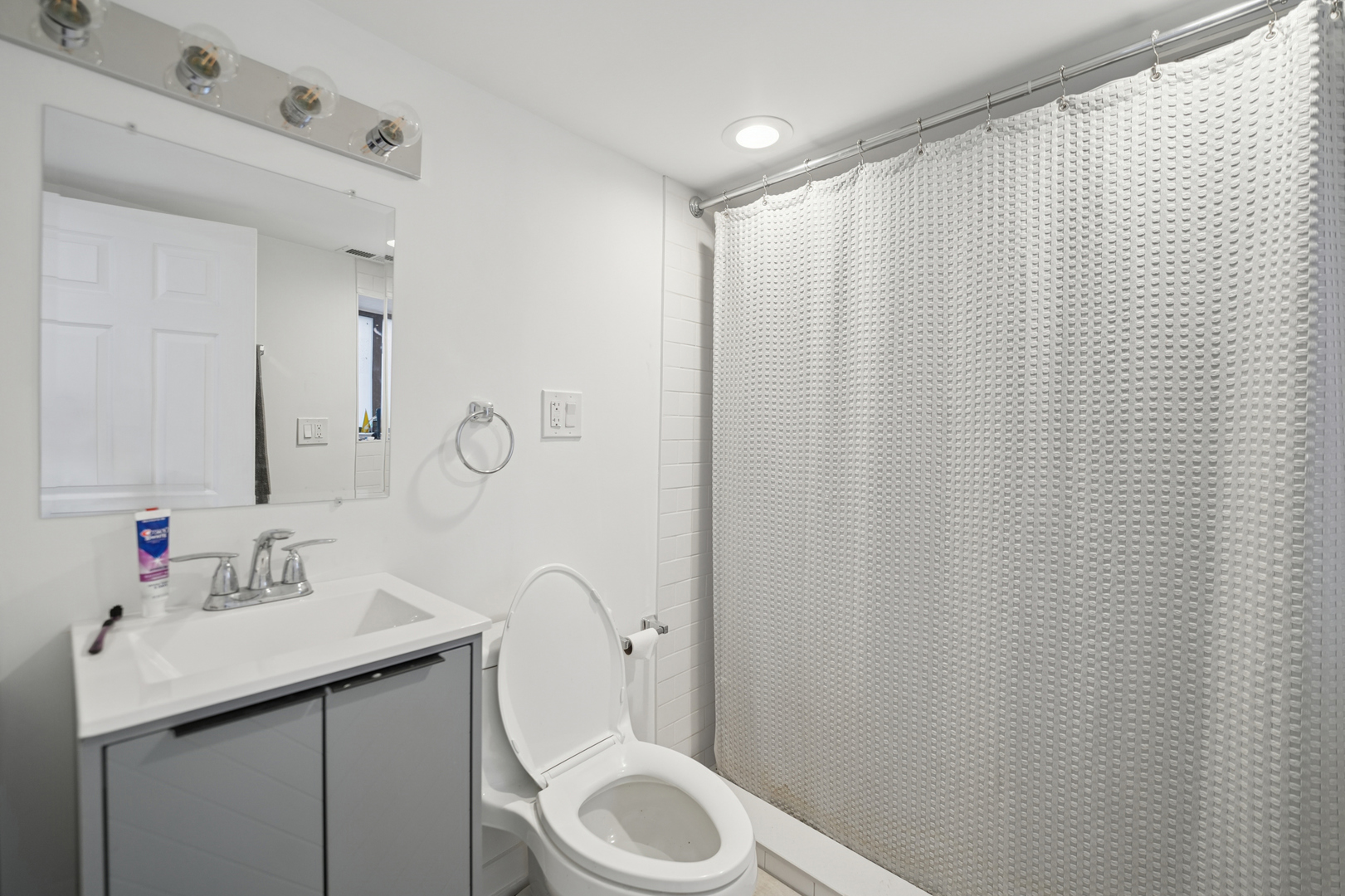4954 West Byron Street Chicago, IL 60641 - Photo 20 of 25 a bathroom with a sink a toilet and shower curtain