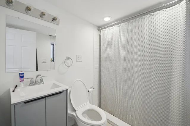 a bathroom with a sink a toilet and shower curtain
