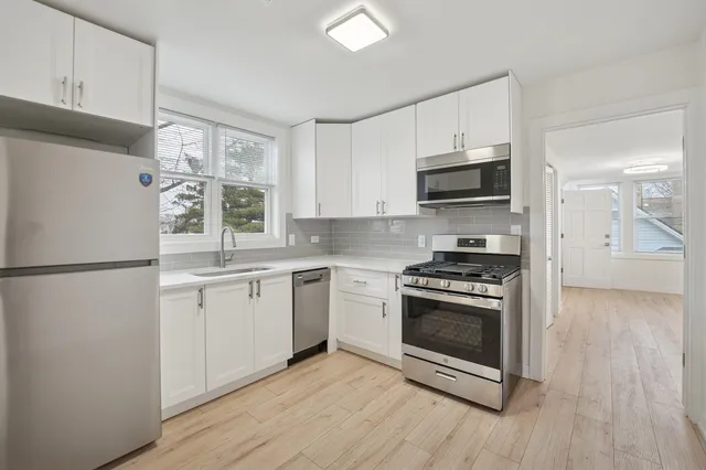 a kitchen with stainless steel appliances a stove a sink and a refrigerator