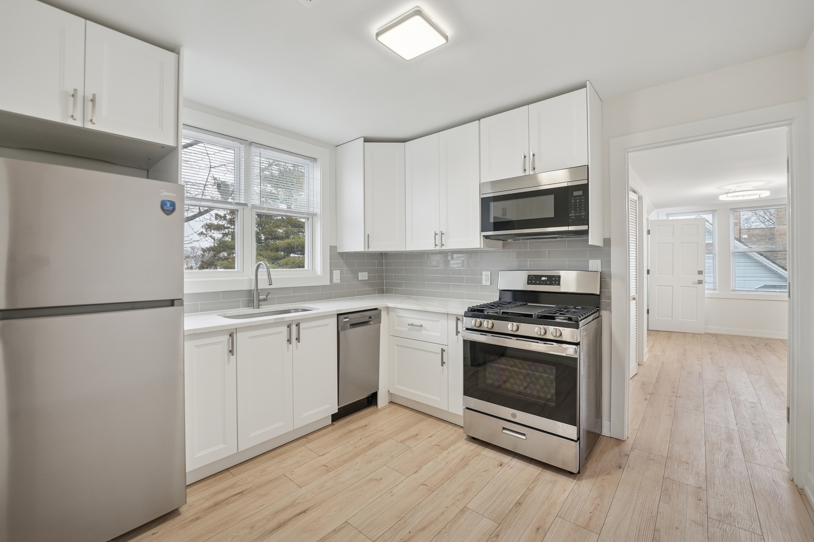 4954 West Byron Street Chicago, IL 60641 - Photo 3 of 33 a kitchen with stainless steel appliances a stove a sink and a refrigerator