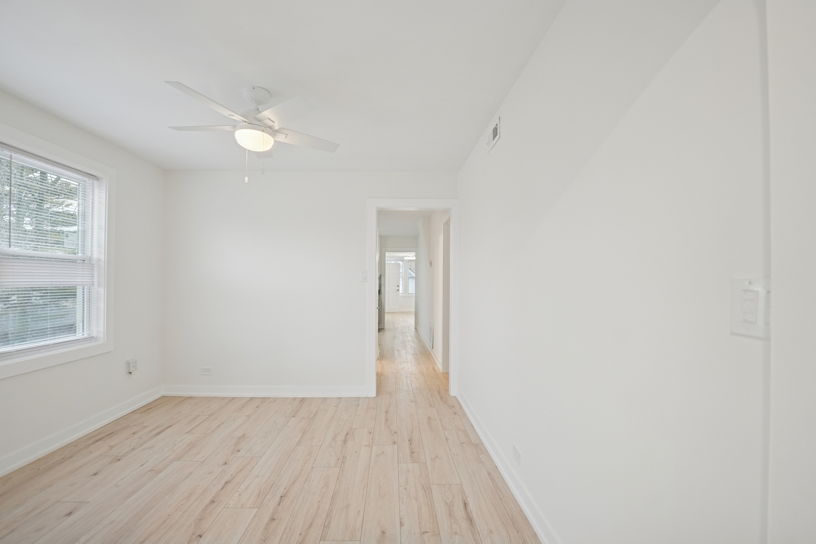 4954 West Byron Street Chicago, IL 60641 - Photo 4 of 33 an empty room with wooden floor and windows