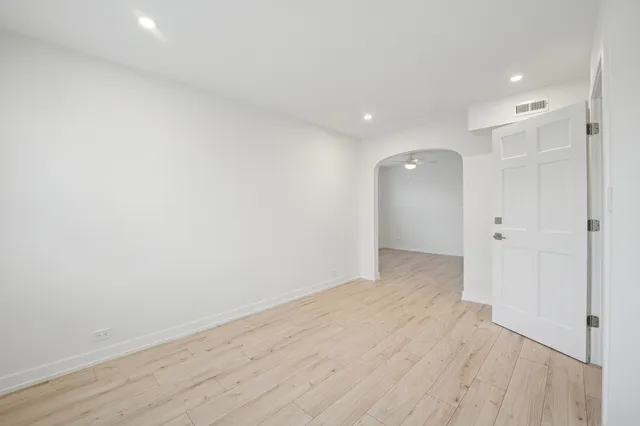 a view of an empty room with wooden floor