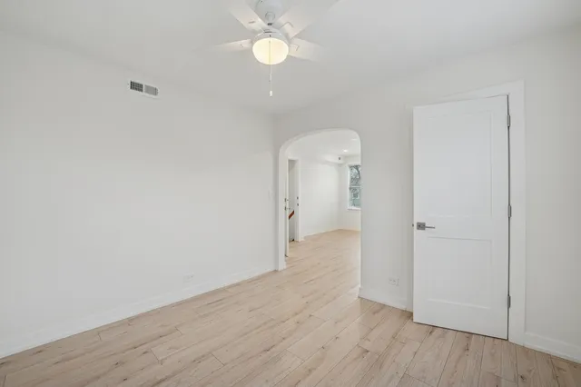 a view of a room with wooden floor and a ceiling fan