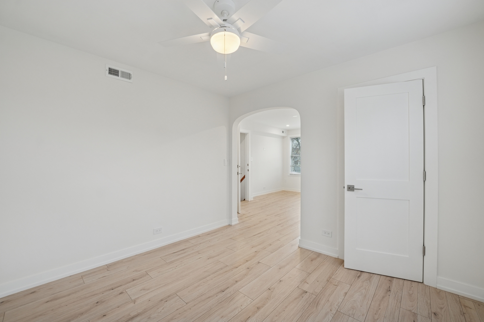 4954 West Byron Street Chicago, IL 60641 - Photo 7 of 33 a view of a room with wooden floor and a ceiling fan