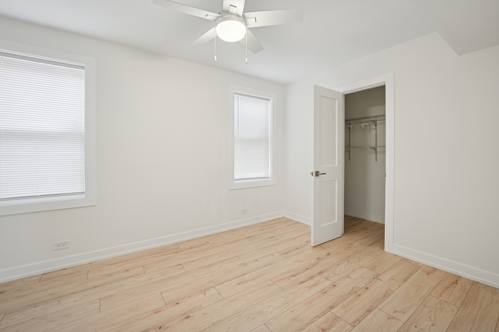 4954 West Byron Street Chicago, IL 60641 - Photo 9 of 33 an empty room with wooden floor and windows
