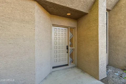 an empty room with wooden floor closet and windows