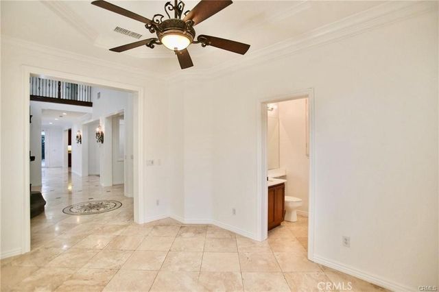 a view of a hallway with a chandelier fan and windows