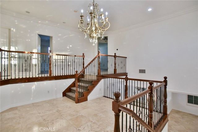 a view of staircase with railing and a chandelier