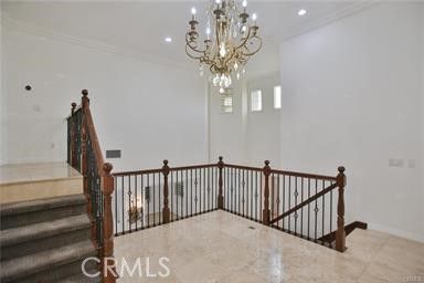 a view of staircase with railing and a chandelier