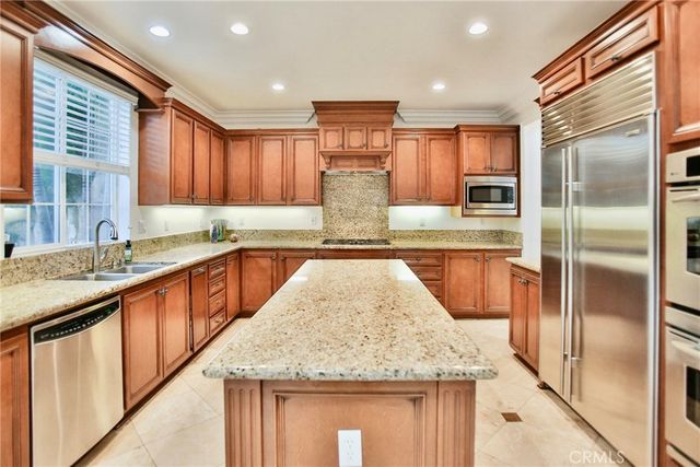 a kitchen with stainless steel appliances granite countertop wooden cabinets and a counter top space