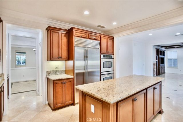 a kitchen with large window a sink and a wooden cabinets