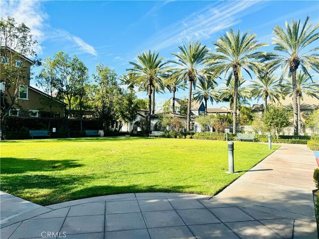 a view of a house with a big yard and palm trees
