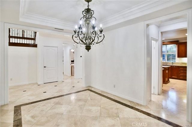 a view of a hallway with chandelier and entryway