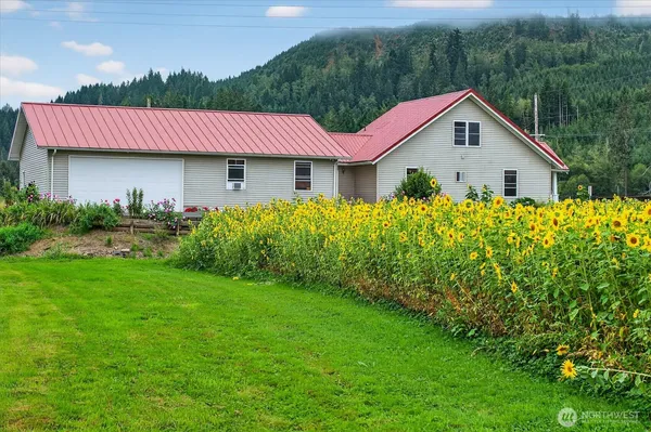 a view of a house with a big yard and potted plants