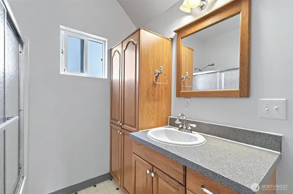 a bathroom with a granite countertop sink and a mirror