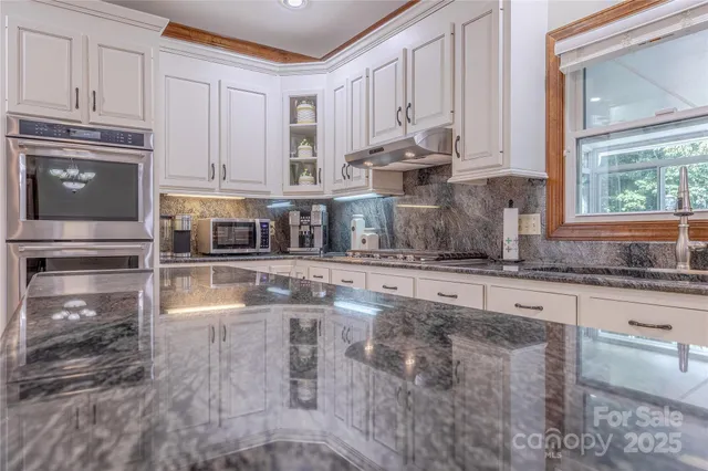 a kitchen with stainless steel appliances granite countertop a stove a sink and a granite counter tops